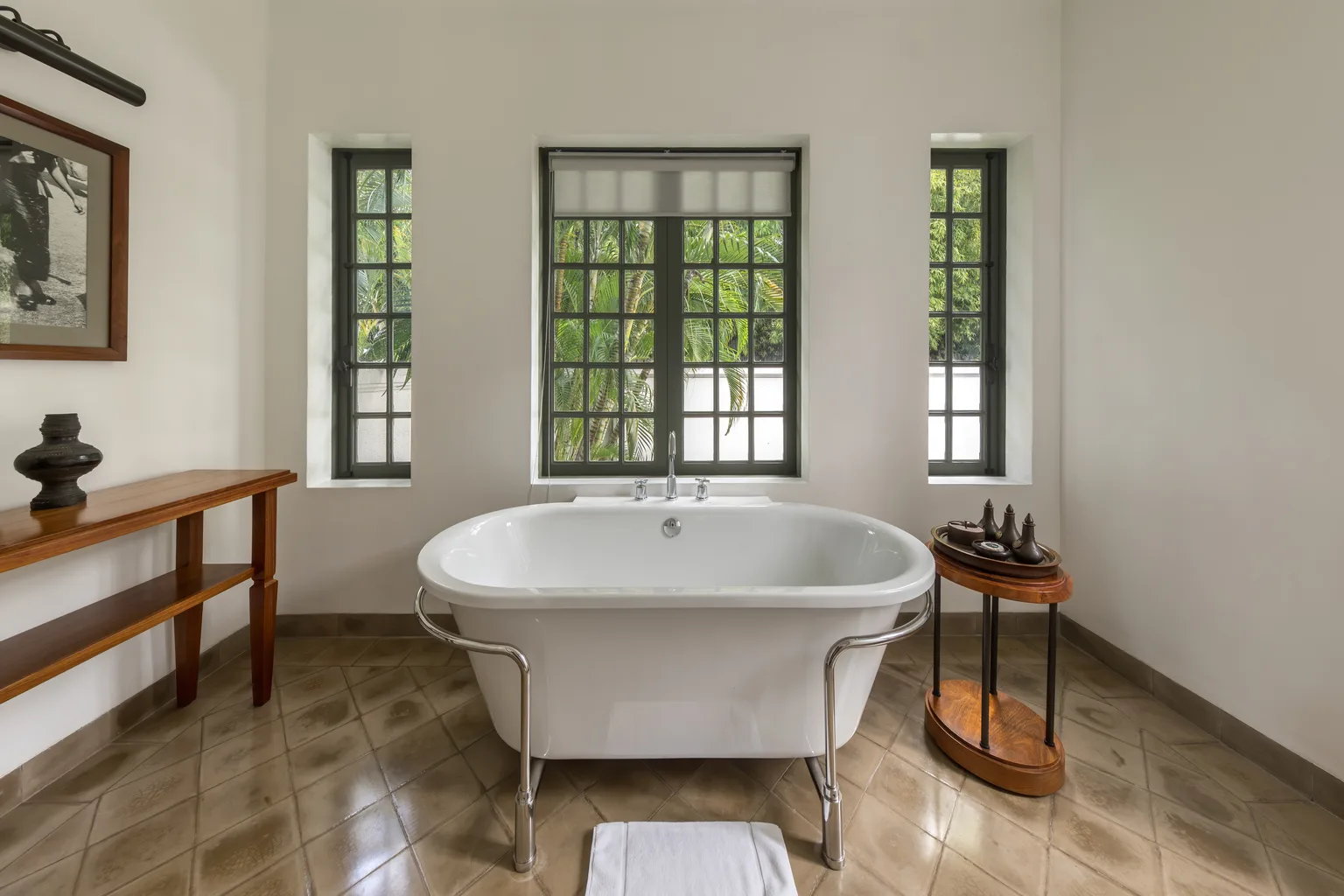 Baignoire îlot dans une salle de bains rénovée, fenêtres à croisillons